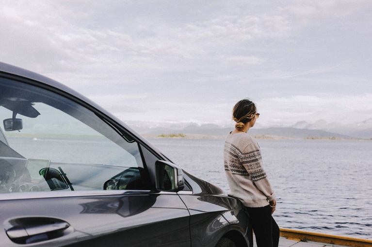 Woman leaning on car
