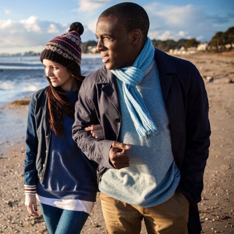two people walking on a beach