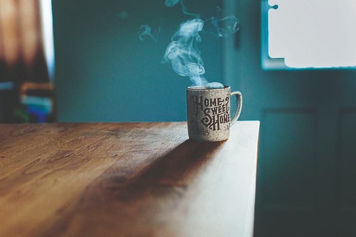 cup saying 'Home Sweet Home' on table.