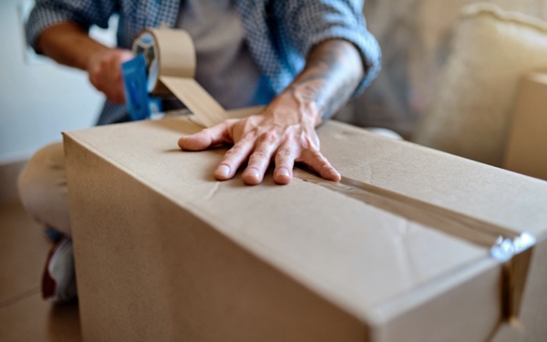 Cardboard box being sealed with packing tape