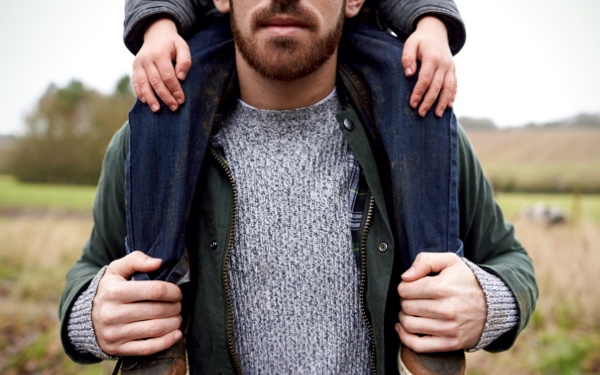 Child sitting on parent's shoulders