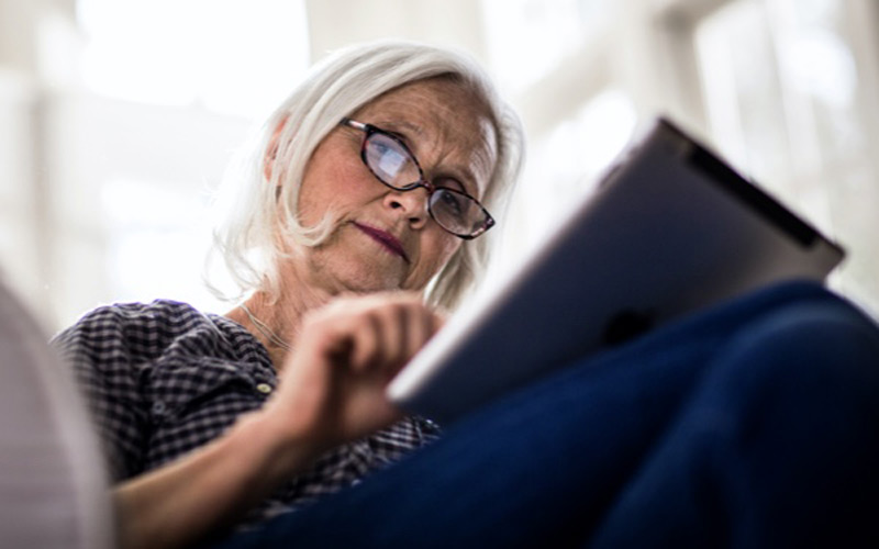 Older woman with glasses using tablet