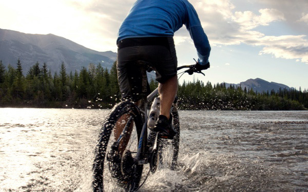 Person cycling through water